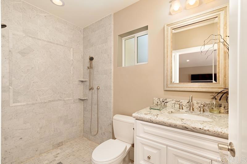 6301 Allston Street Carlsbad, CA 92009 - Photo 40 of 73 a bathroom with a granite countertop sink toilet and shower