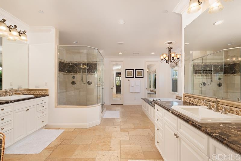 6301 Allston Street Carlsbad, CA 92009 - Photo 44 of 73 a large bathroom with a granite countertop tub a double vanity sink a mirror and shower