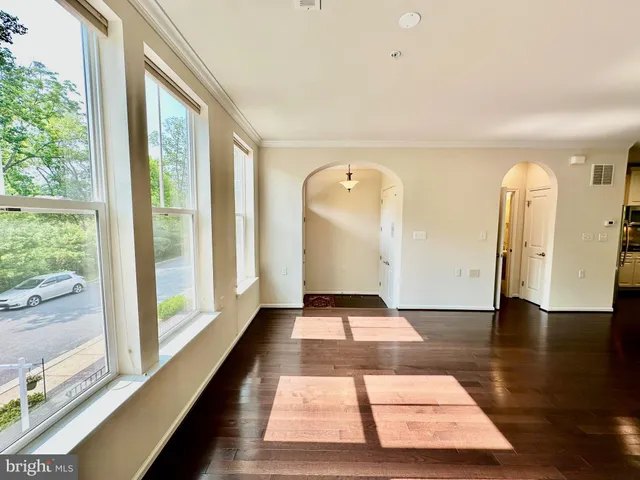 an empty room with wooden floor and window