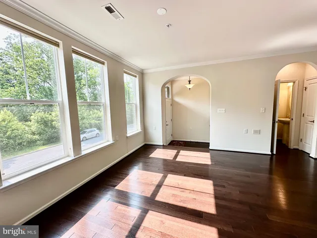 a open kitchen with stainless steel appliances granite countertop a refrigerator a stove top oven and a dining table with wooden floor