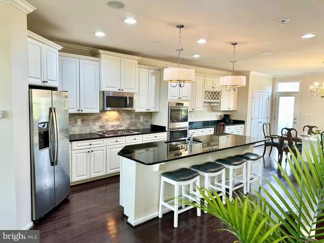 a kitchen with granite countertop a table chairs microwave and cabinets