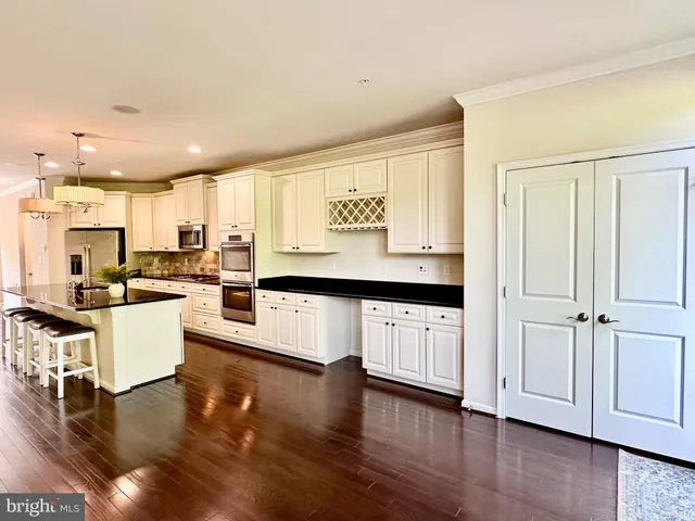 a large white kitchen with a large window a oven and white cabinets