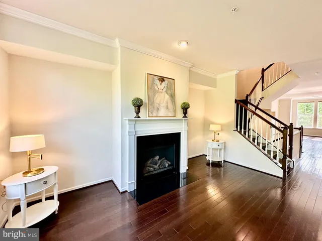 a living room with wooden floor and a fireplace