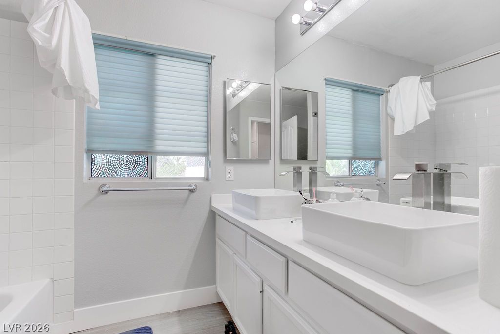 1 Rising Sun Court Henderson, NV 89074 - Photo 29 of 47 Modern vessel sinks and crisp white cabinetry create a sleek, functional bathroom space.