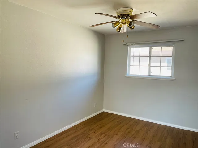an empty room with a window and a fan