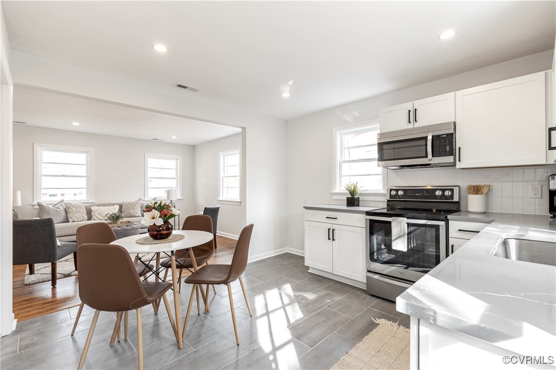 2106 Ridgemont Road Richmond, VA 23224 - Photo 18 of 32 Kitchen with white cabinetry, appliances with stai