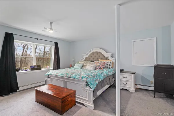 a bedroom with a bed and large windows