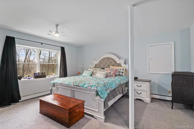 a bedroom with a bed and large windows