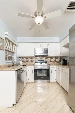 a kitchen with stainless steel appliances granite countertop a stove and cabinets