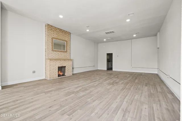 an empty room with wooden floor and fireplace