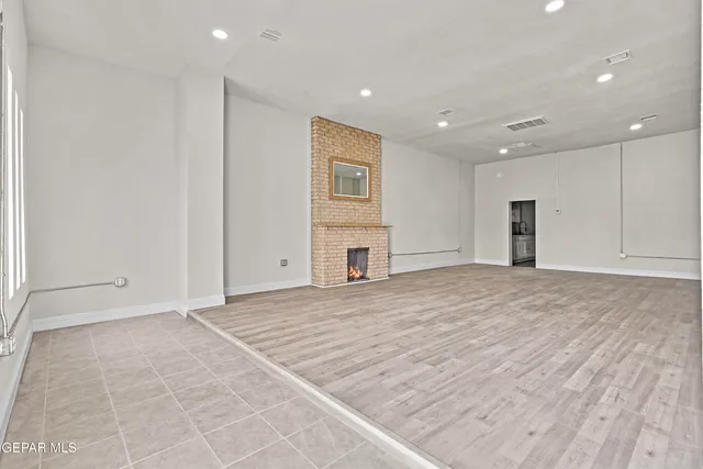 a view of empty room with wooden floor and fireplace