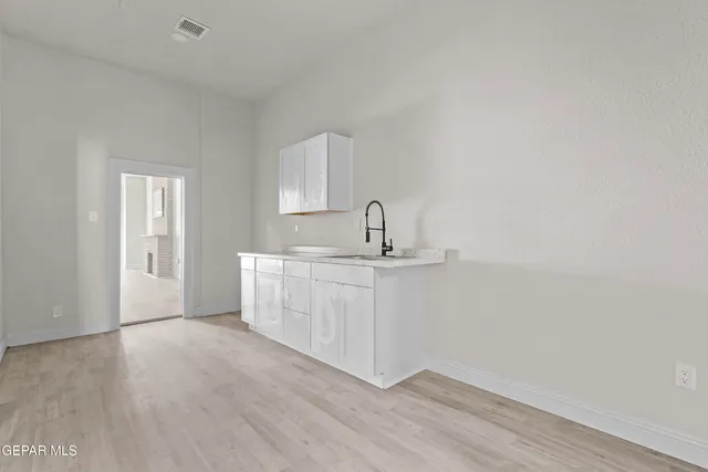a view of a kitchen with white cabinets