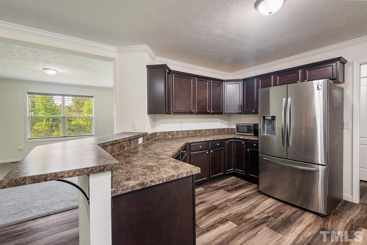 517 Circle B Farm Road Rougemont, NC 27572 - Photo 11 of 37 a kitchen with granite countertop a refrigerator and a sink