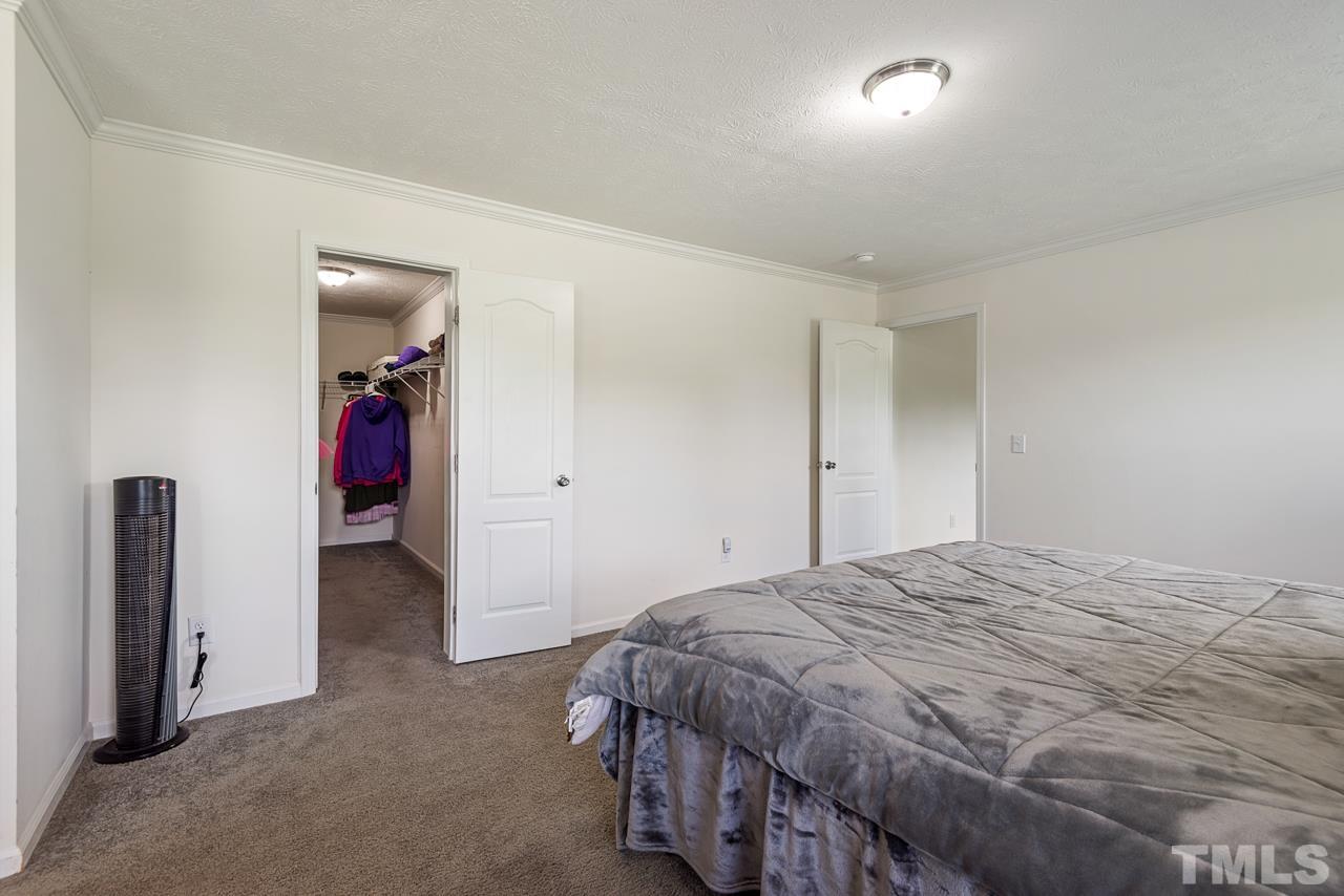 517 Circle B Farm Road Rougemont, NC 27572 - Photo 17 of 37 a spacious bedroom with a bed and a walk in closet