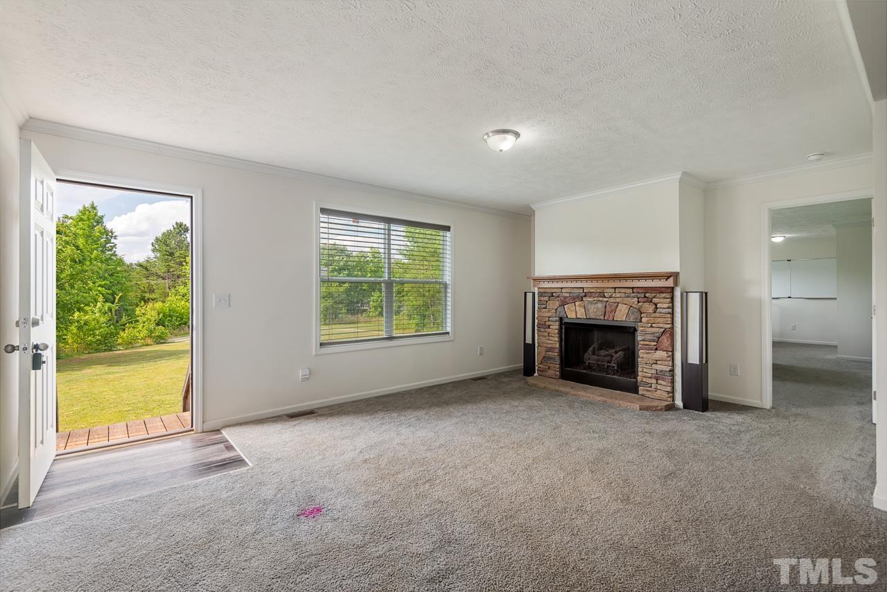 517 Circle B Farm Road Rougemont, NC 27572 - Photo 4 of 37 an empty room with windows fireplace and a yard