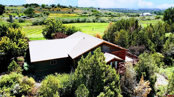 an aerial view of a house with a yard and lake view