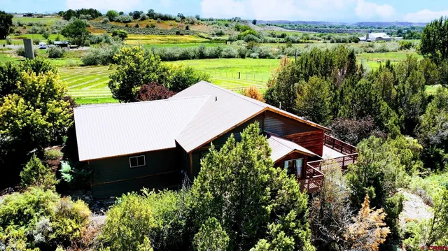 an aerial view of a house with a yard and lake view