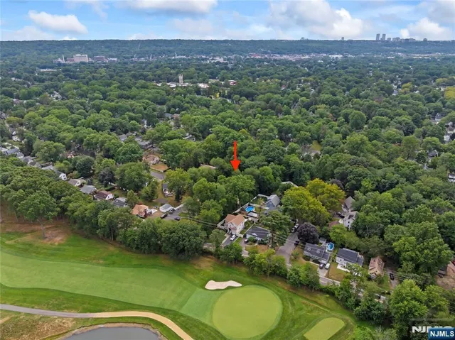 an aerial view of a houses with a yard and lake view