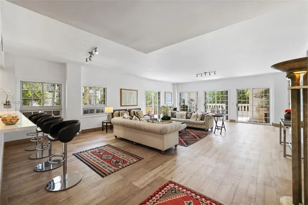 a living room with furniture kitchen view and a flat screen tv
