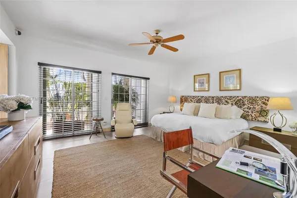 a spacious bedroom with a bed a large window couch and table