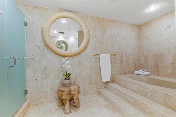 a spacious bedroom with a bed and painting on the wall