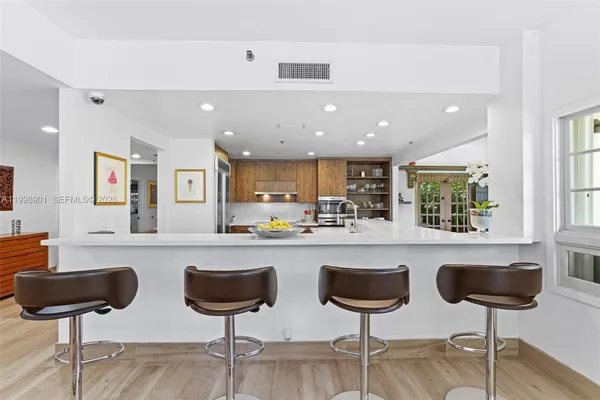 a large kitchen with stainless steel appliances a large counter top a stove and a refrigerator