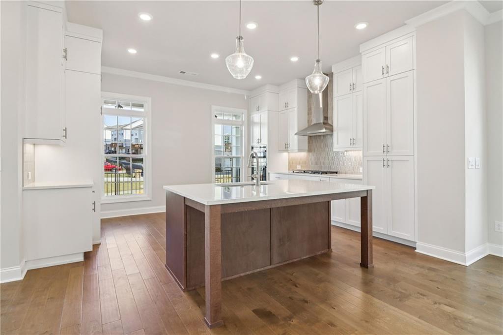 159 Basil Street Cumming, GA 30040 - Photo 13 of 70 a kitchen with kitchen island a sink stainless steel appliances and cabinets