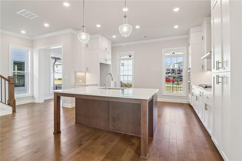 159 Basil Street Cumming, GA 30040 - Photo 14 of 70 a large kitchen with granite countertop a large counter top a sink stainless steel appliances and cabinets