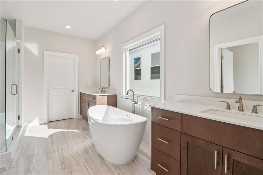 159 Basil Street Cumming, GA 30040 - Photo 25 of 70 a spacious bathroom with a double vanity sink a mirror and a bathtub