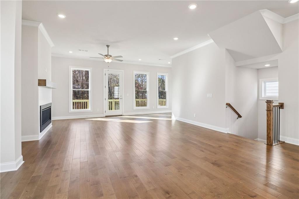 159 Basil Street Cumming, GA 30040 - Photo 8 of 70 a view of an empty room with wooden floor and a window
