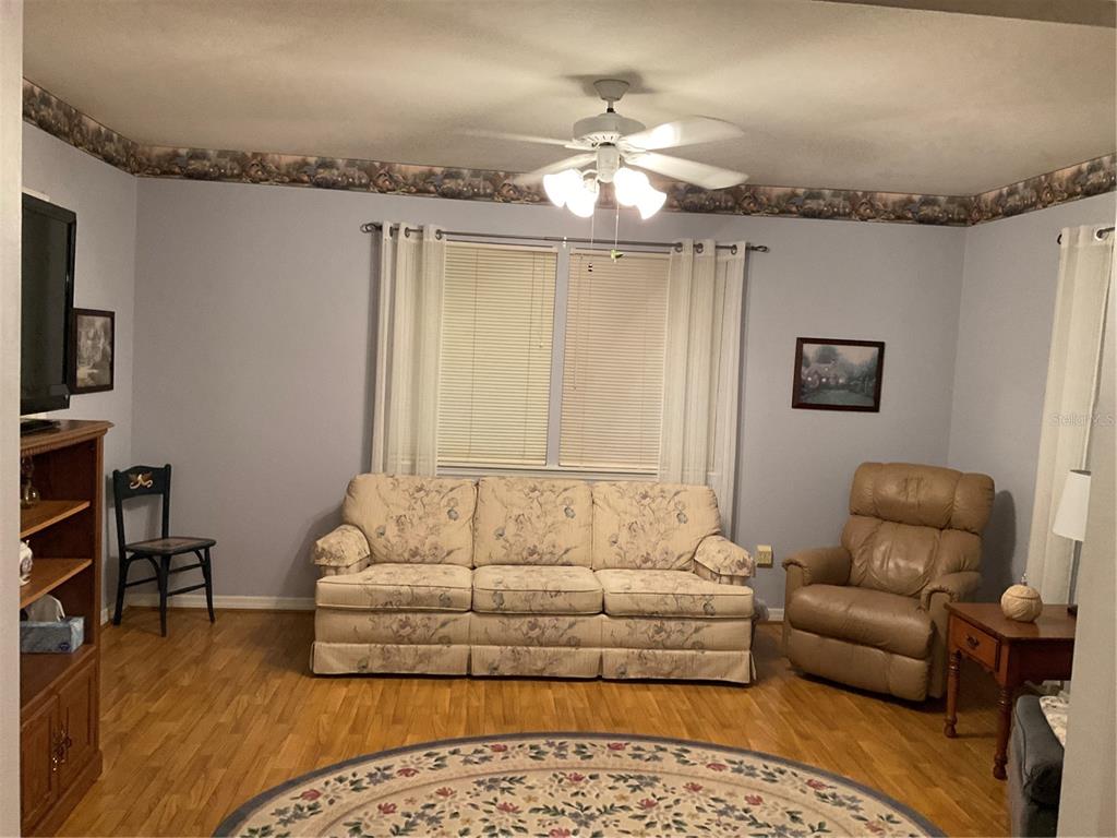 2438 Southeast 32nd Street Okeechobee, FL 34974 - Photo 37 of 42 a living room with furniture and a chandelier
