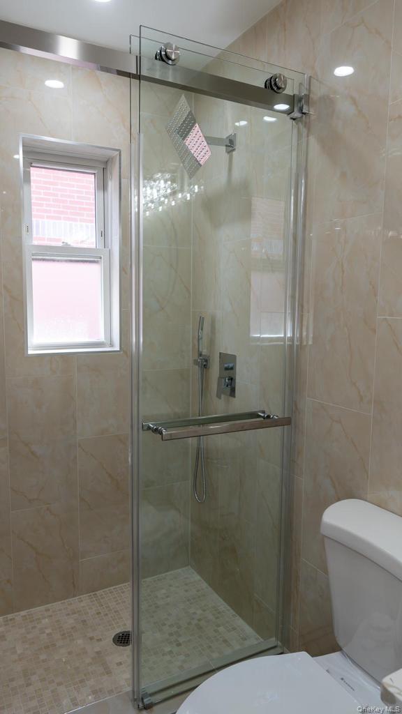 a bathroom with a shower a toilet and a sink