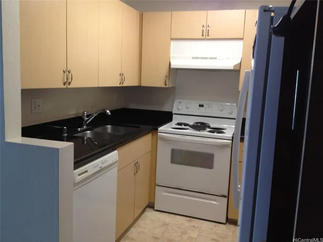 a kitchen with granite countertop white cabinets and white appliances
