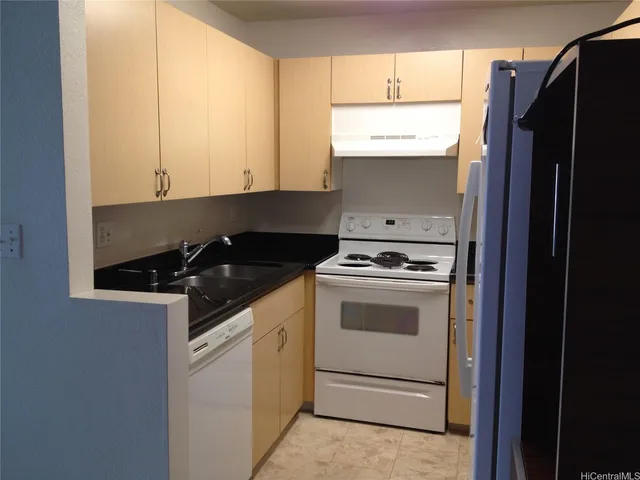 a kitchen with granite countertop white cabinets and white appliances