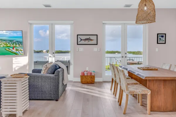 a kitchen with stainless steel appliances granite countertop a stove a sink dishwasher a refrigerator and white cabinets with wooden floor