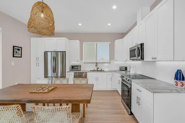 a kitchen with stainless steel appliances granite countertop a stove a sink dishwasher and a microwave oven with wooden cabinets