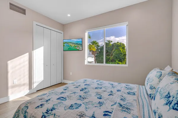 a bedroom with a large bed and a chandelier