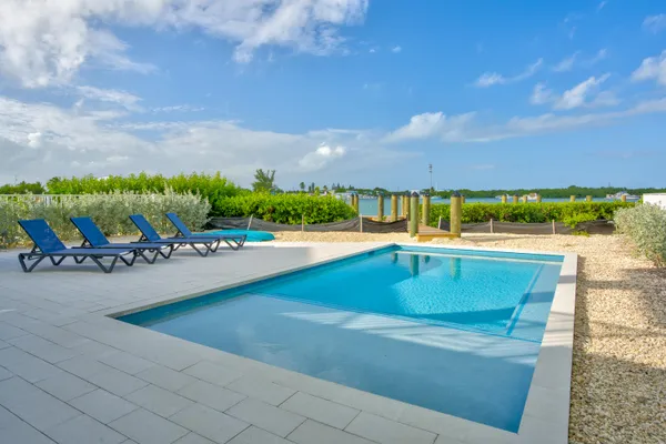 a view of swimming pool with lounge chairs in patio