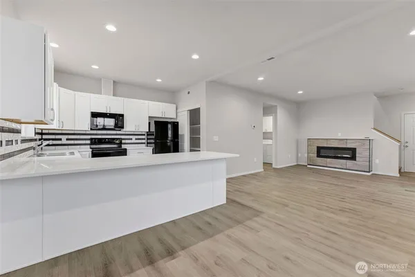 a view of kitchen with stainless steel appliances granite countertop a stove a sink and a microwave
