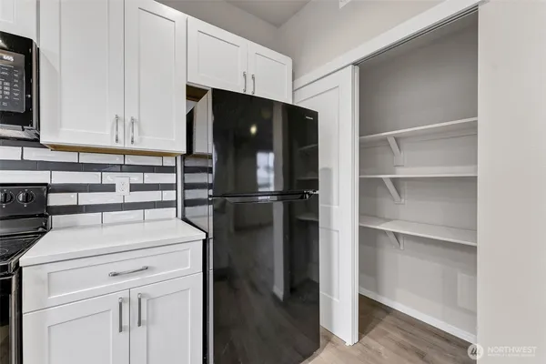 a kitchen with a refrigerator and a stove top oven