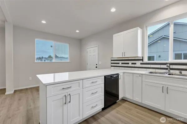 a kitchen with white cabinets and sink