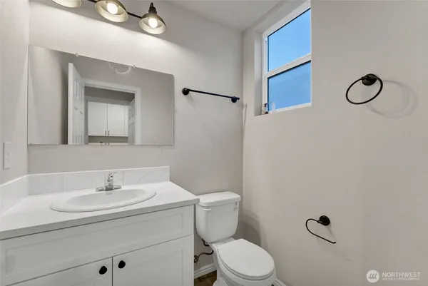 a bathroom with a toilet sink and mirror