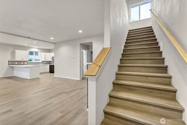 a view of a kitchen with wooden floor and stairs