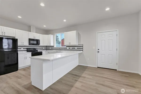 a kitchen with white cabinets and sink