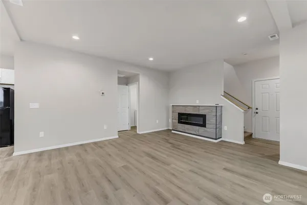 a view of an empty room with a fireplace and a window