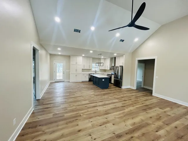 a kitchen with stainless steel appliances granite countertop a refrigerator sink and white cabinets