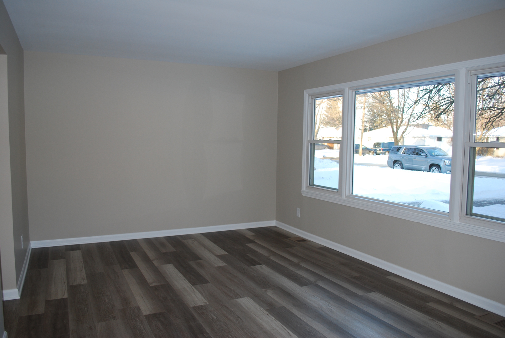 1109 Westminster Road Joliet, IL 60435 - Photo 4 of 20 a view of an empty room with wooden floor and a window