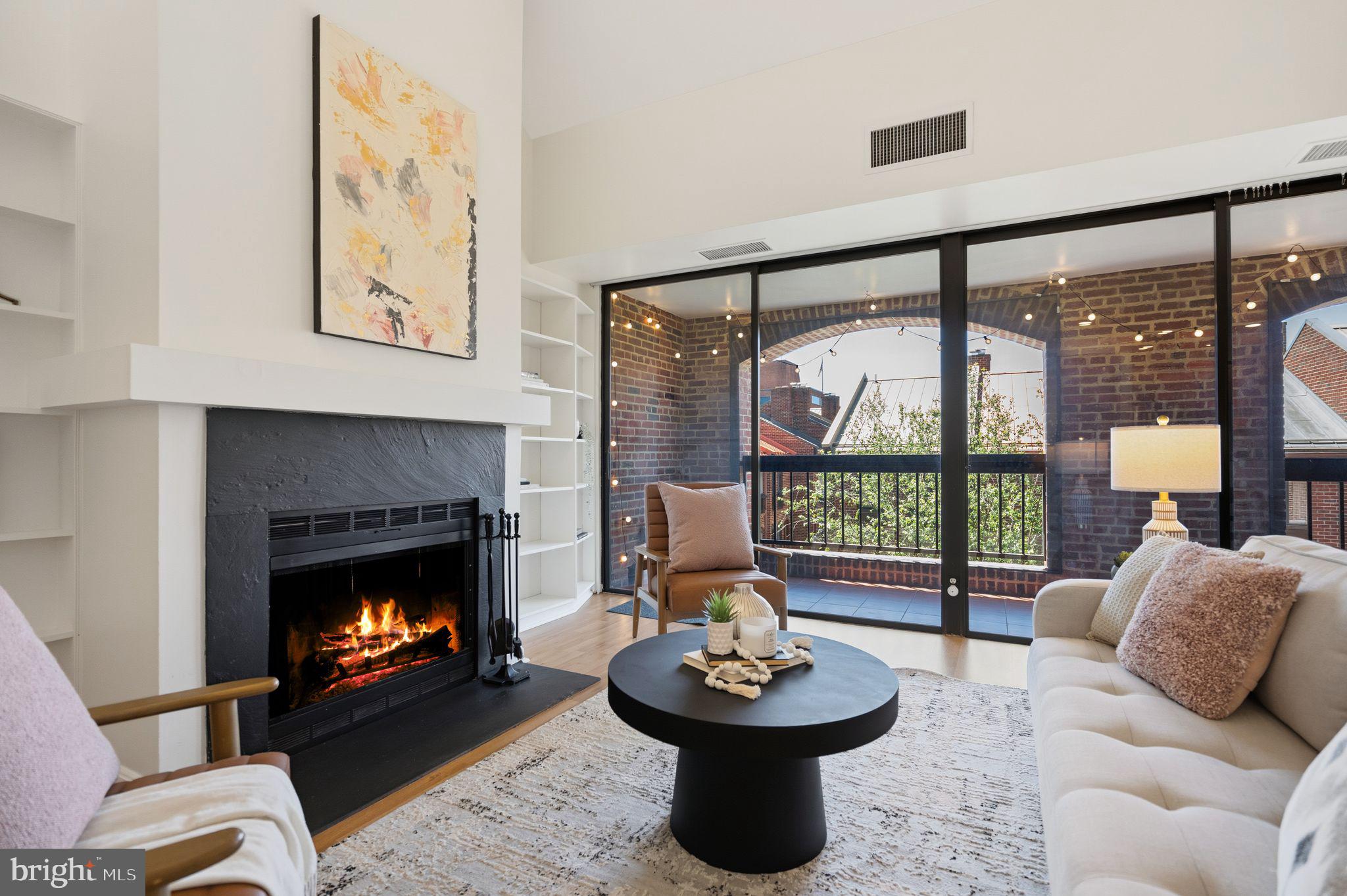 3225 Grace Street Northwest, Unit 226 Washington, DC 20007 - Photo 5 of 45 a living room with furniture a fireplace and a floor to ceiling window