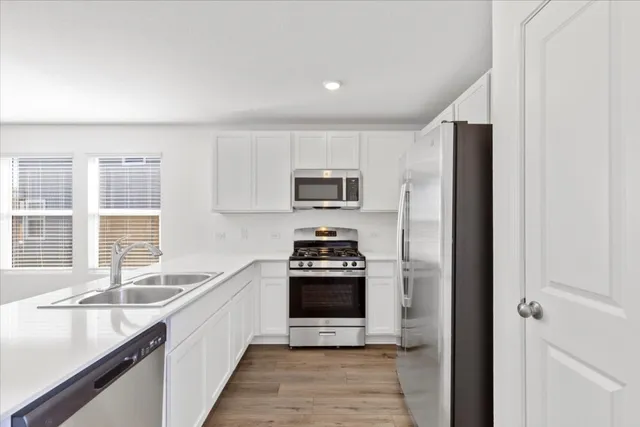 a open kitchen with a sink stove and microwave