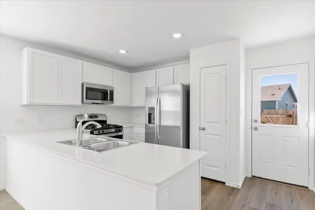 a kitchen with granite countertop stainless steel appliances a sink stove and refrigerator